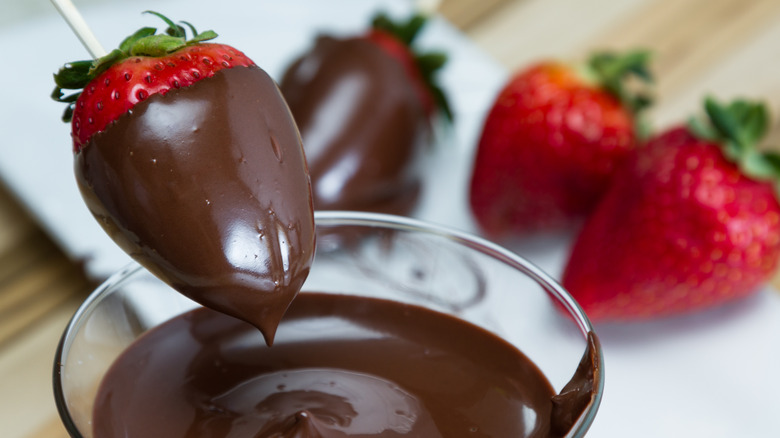 Dipping strawberry in melted chocolate