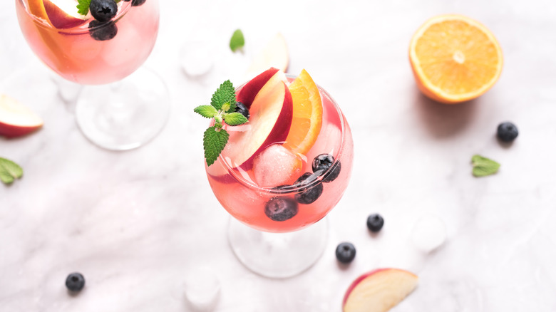 Pink cocktail with ice and fruit 