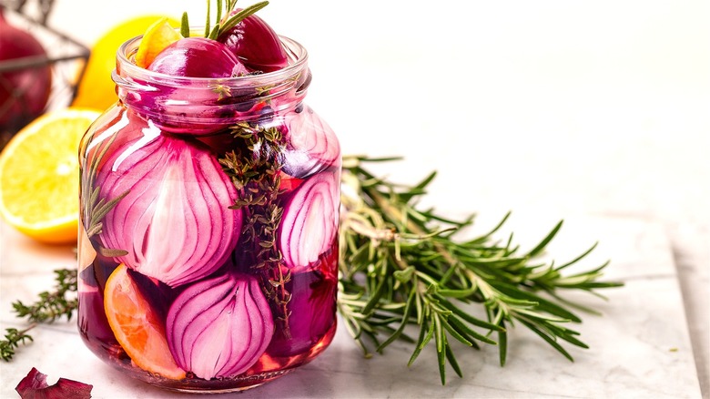 Pickled onions in jar with herbs 