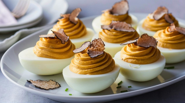 Deviled eggs with shaved truffle on a plate.