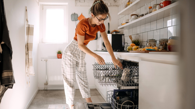 woman using dishwasher