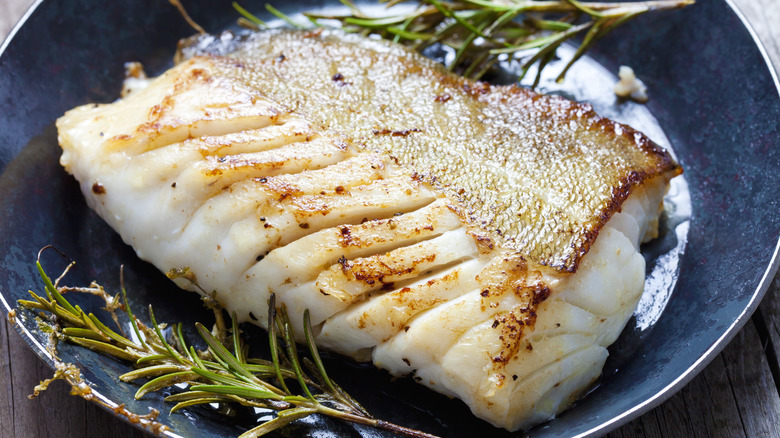 White fish on plate with herbs