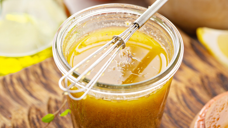 whisk atop jar of vinaigrette 