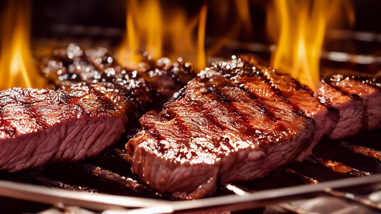 Steak on a grill with flames