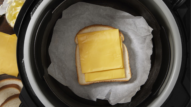 two slices of American cheese on bread in pan
