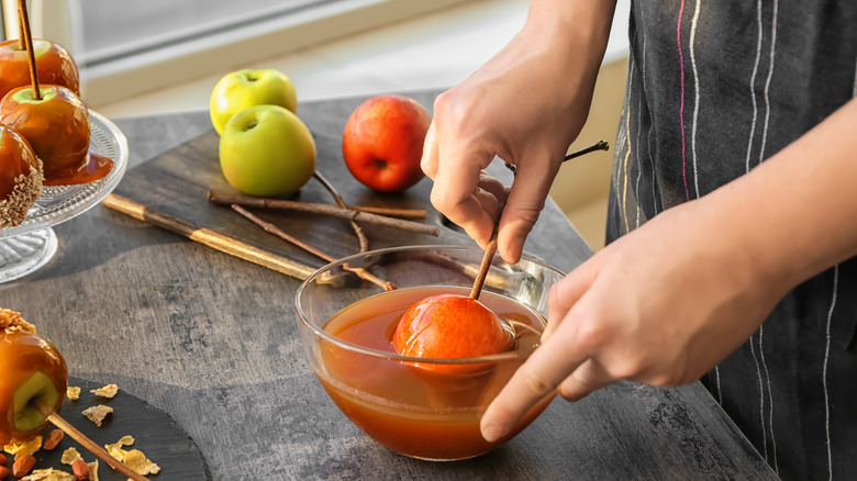 Dipping apples in caramel