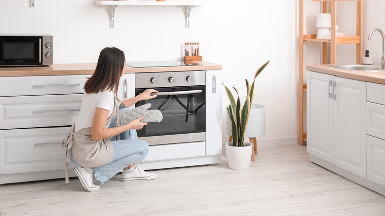 woman checking on oven