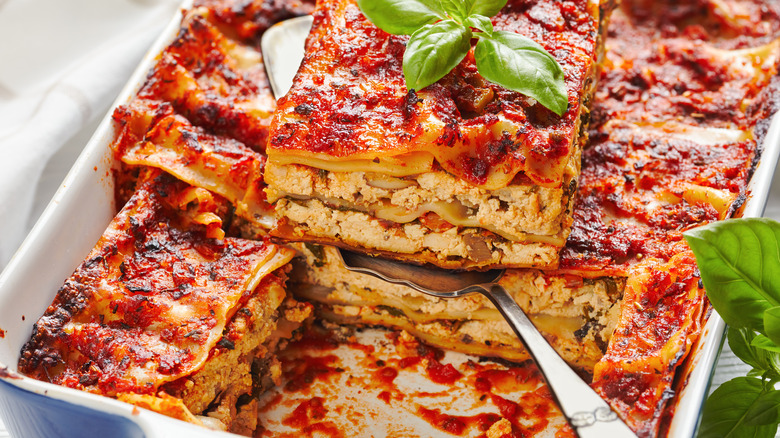 Lasagna piece being lifted out of lasagna tray