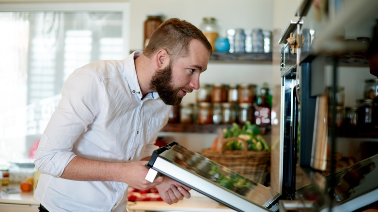 man opening oven door