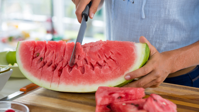 Person cutting a watermelon