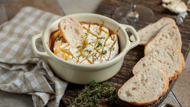 Baked brie cheese served in a bowl with bread.