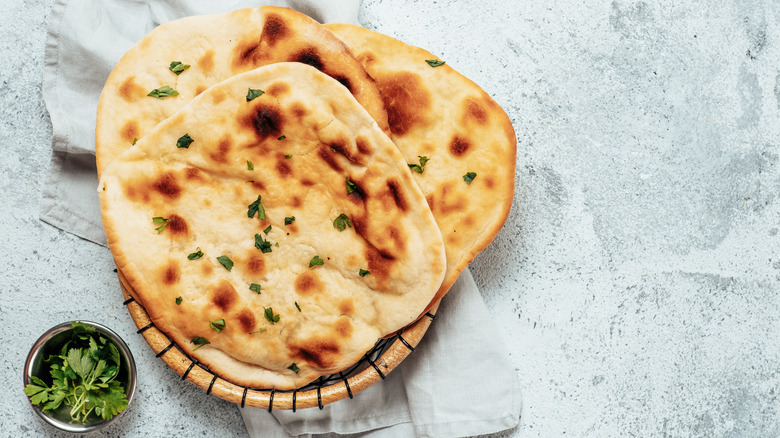 naan bread in basket with herbs