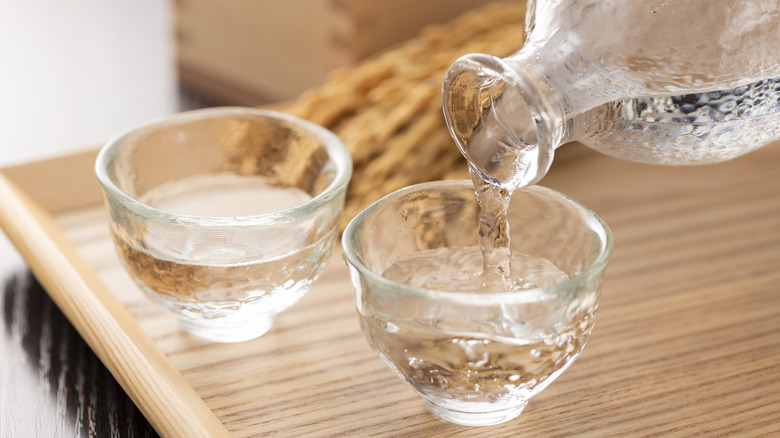 Pouring sake into two glasses