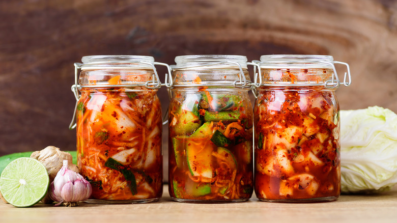 Different types of kimchi in glass jars 