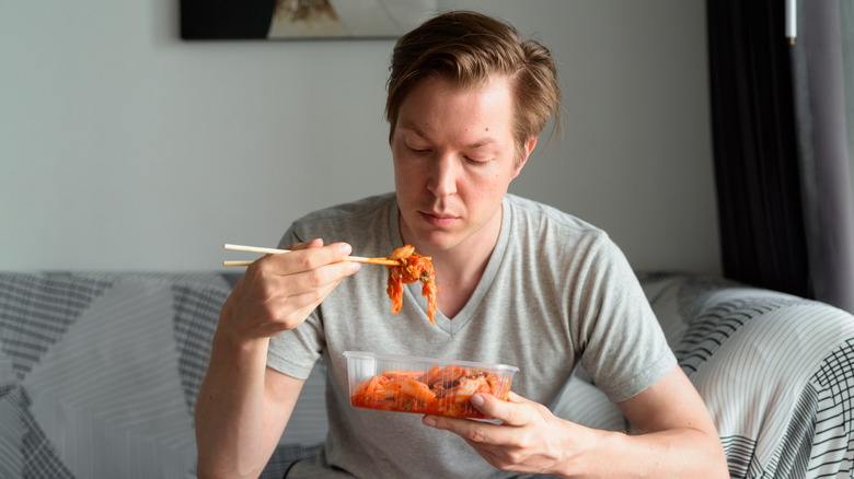 Man eating kimchi on the couch 