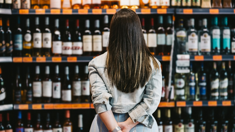 Person looking at shelves of wine in a wine store