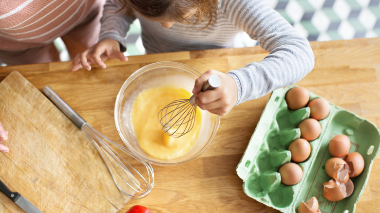 child beating eggs