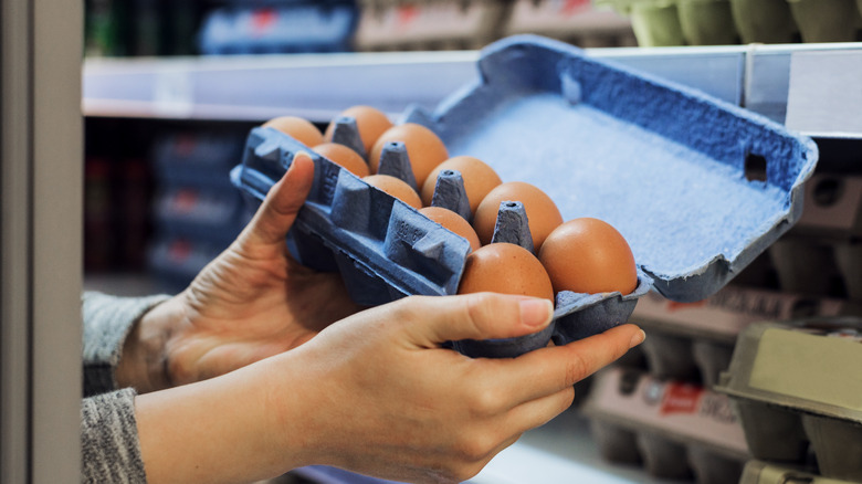 person holding egg carton