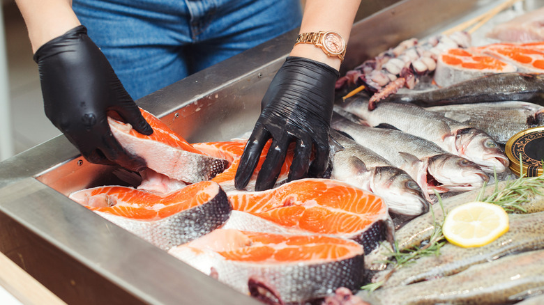 A fishmonger handling raw fish