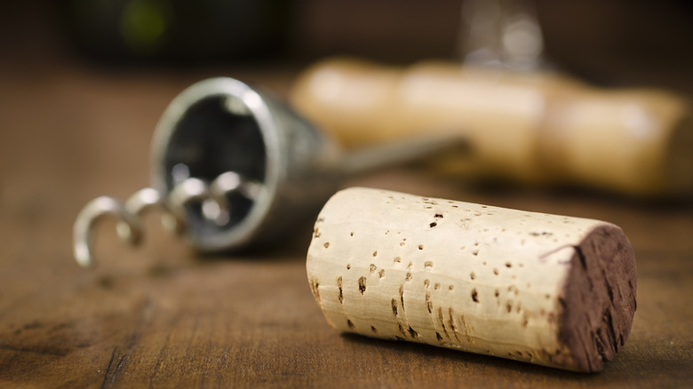 Extreme closeup on cork and corkscrew on table