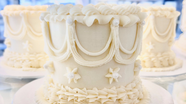 three decorated white cakes