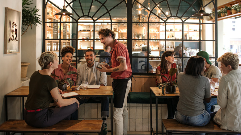 A group of diners speak to a server