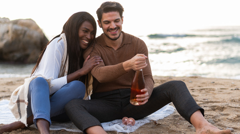 Couple on the beach enjoying wine