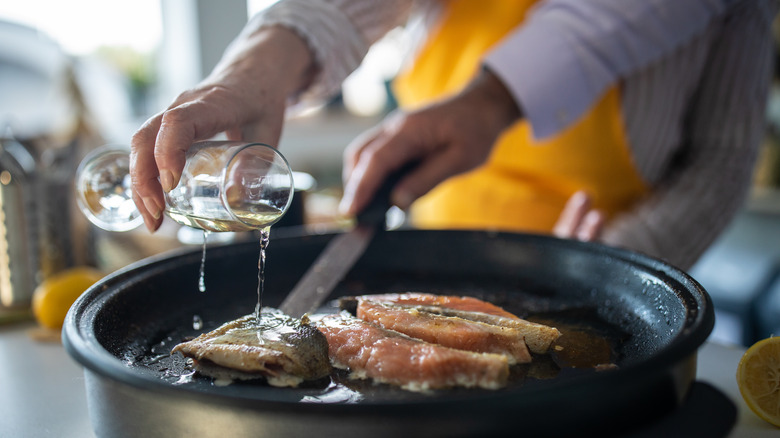 Person cooking with white wine