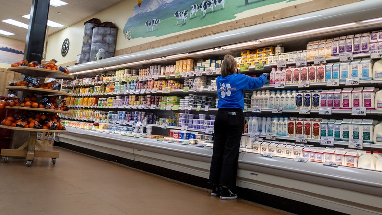 A Trader Joe's employee organizes dairy products