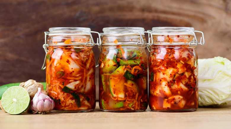 Three jars of different spicy kimchi with cabbage