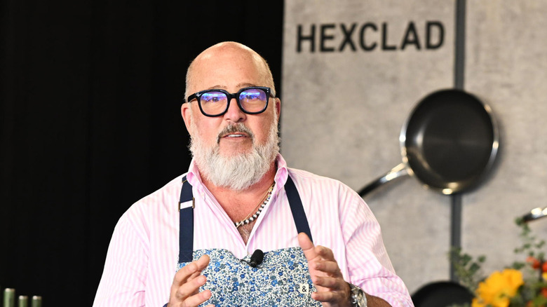 Andrew Zimmern wearing an apron