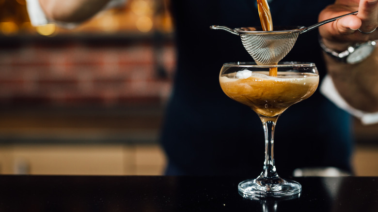 Bartender straining espresso martini