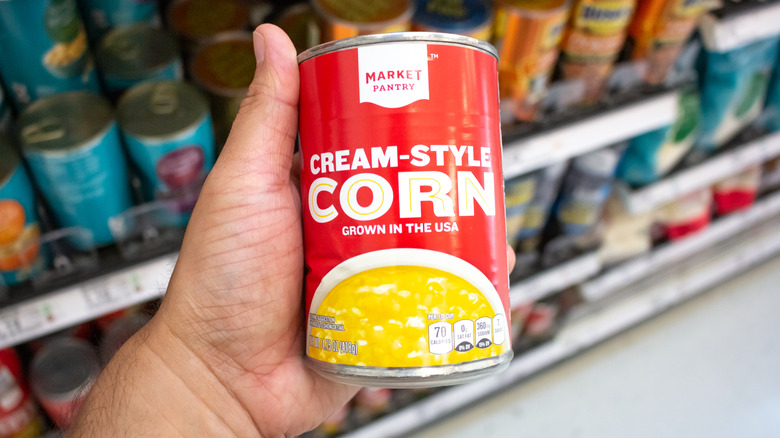 Person holding a can of cream-style corn