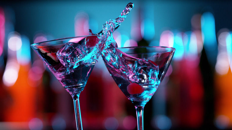 two splashing martinis bottles background