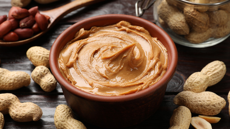 Peanut butter in bowl with peanuts