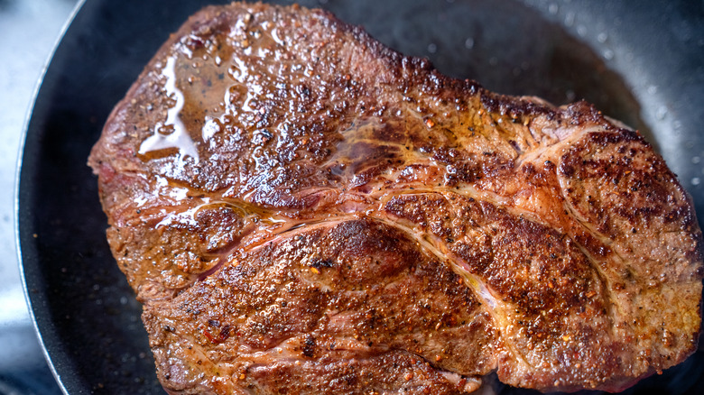 Beef chuck roast cooking in a pan