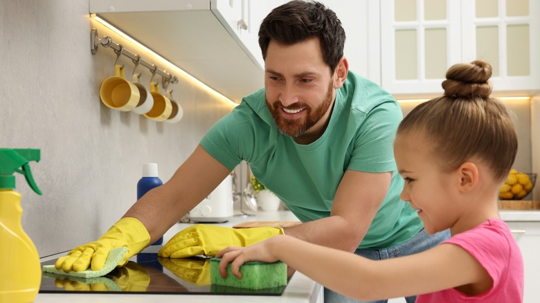 Child and parent cleaning stove