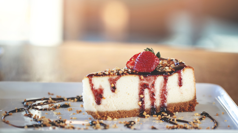 cheesecake topped with fudge and strawberries