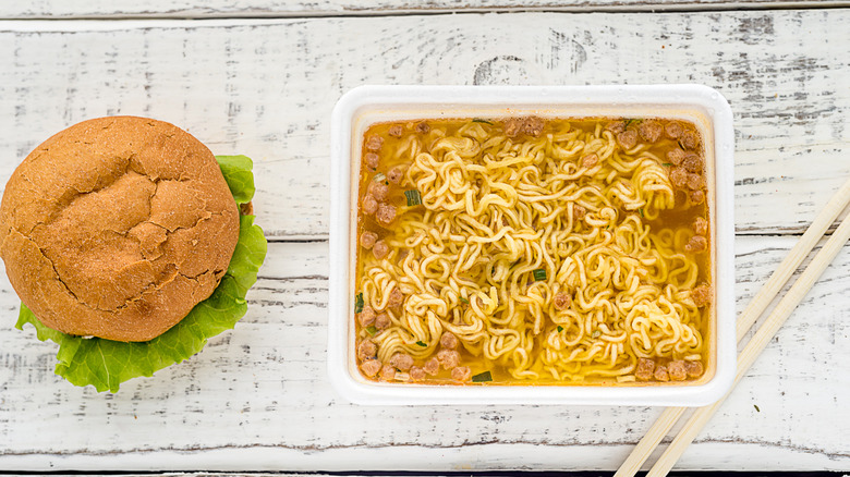 Chinese noodles served with a burger.