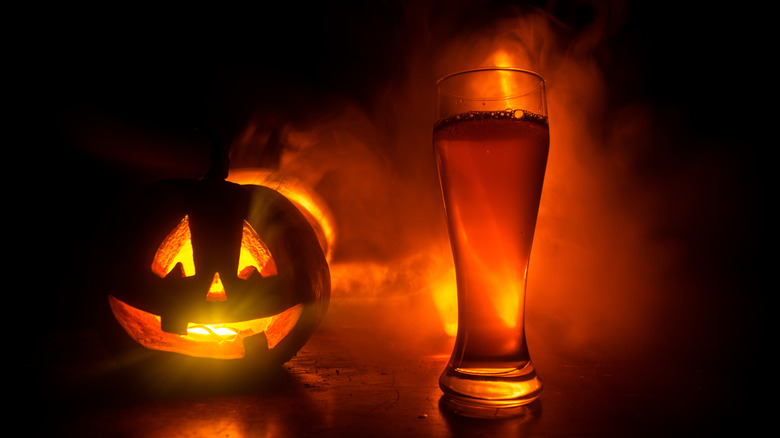 A pumpkin next to a beer