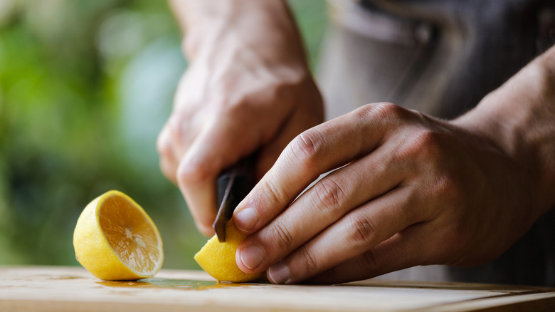 chef's hands cutting a lemon 