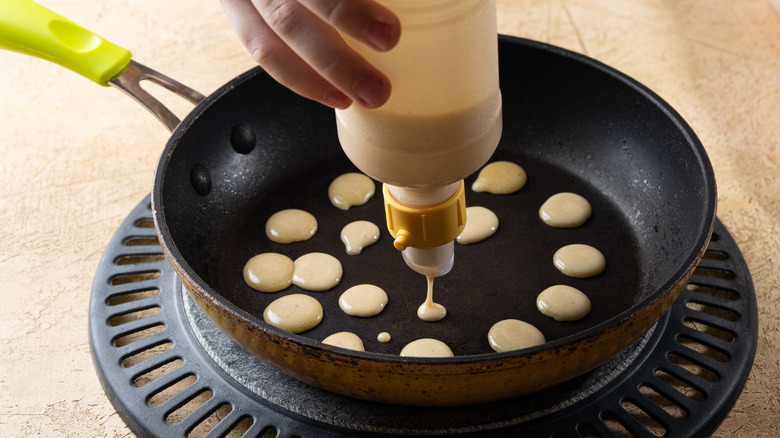 Person using pancake batter squeeze bottle