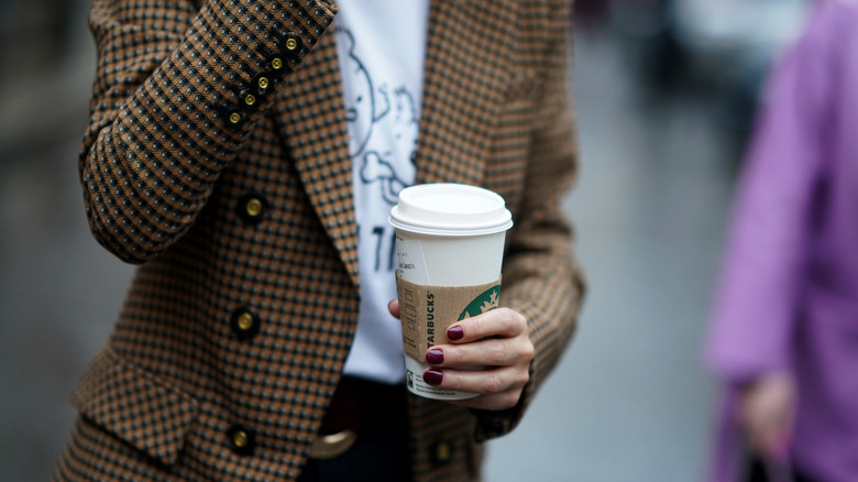 Person holding Starbucks to-go cup