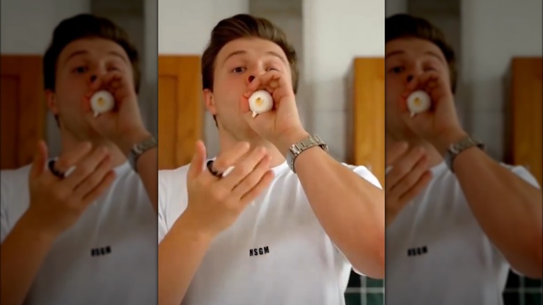 Max Klymenko blowing on egg