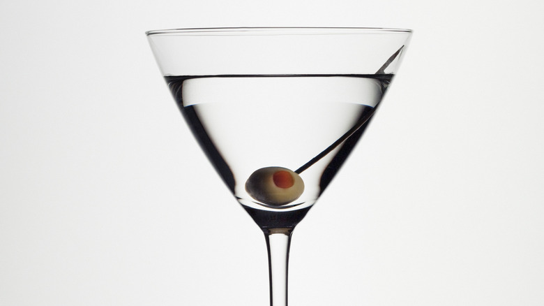 olive martini filling cocktail glass