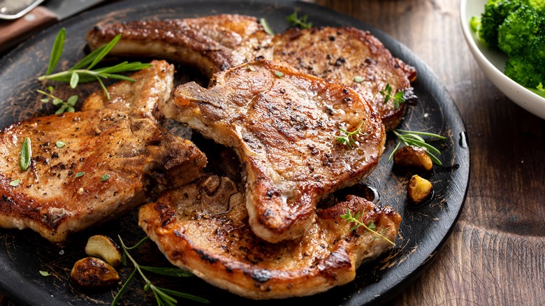 Glazed pork chops on a serving platter with garlic