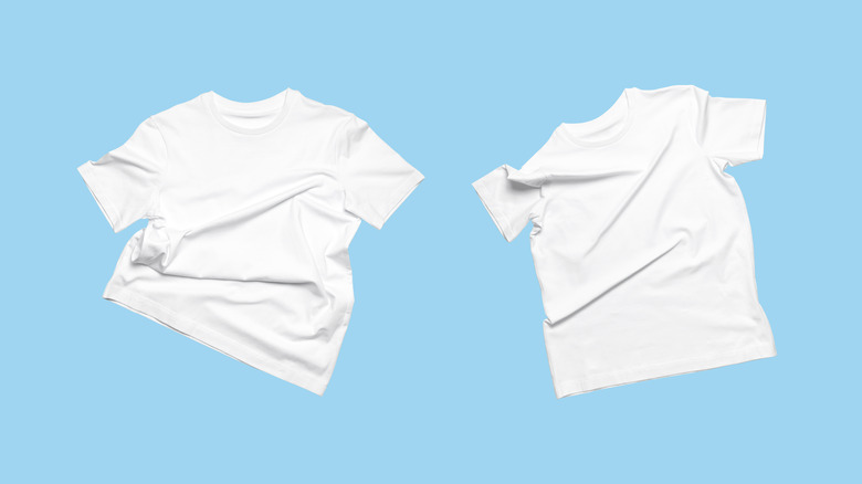 Two plain white t-shirts on blue background