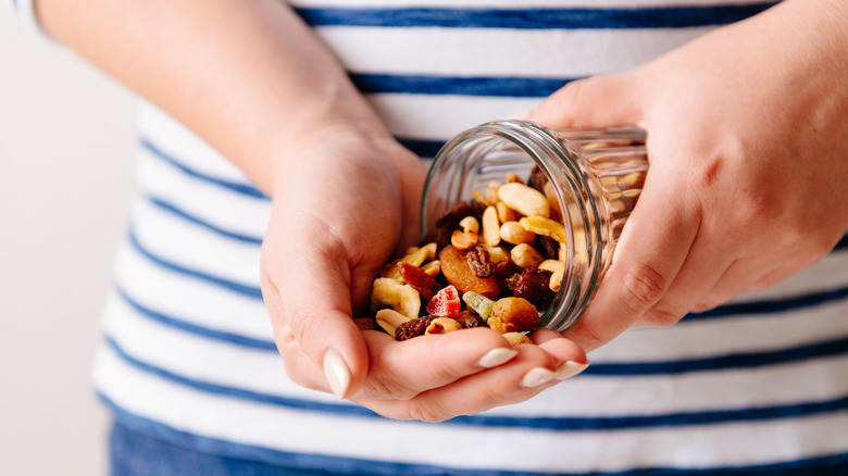 trail mix being poured out of mason jar