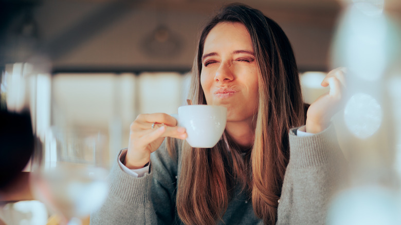 woman reacting to bad coffee