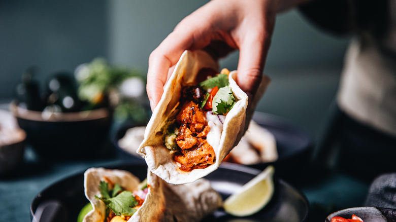 person picking up large taco